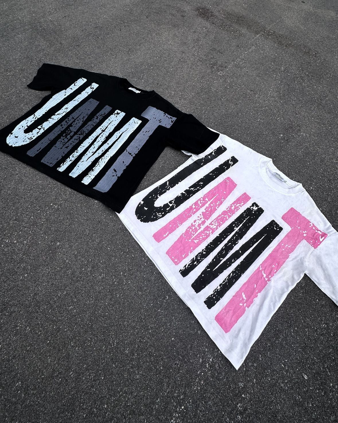 Two of our "DESTINATION" Tee's pictured on a cement background